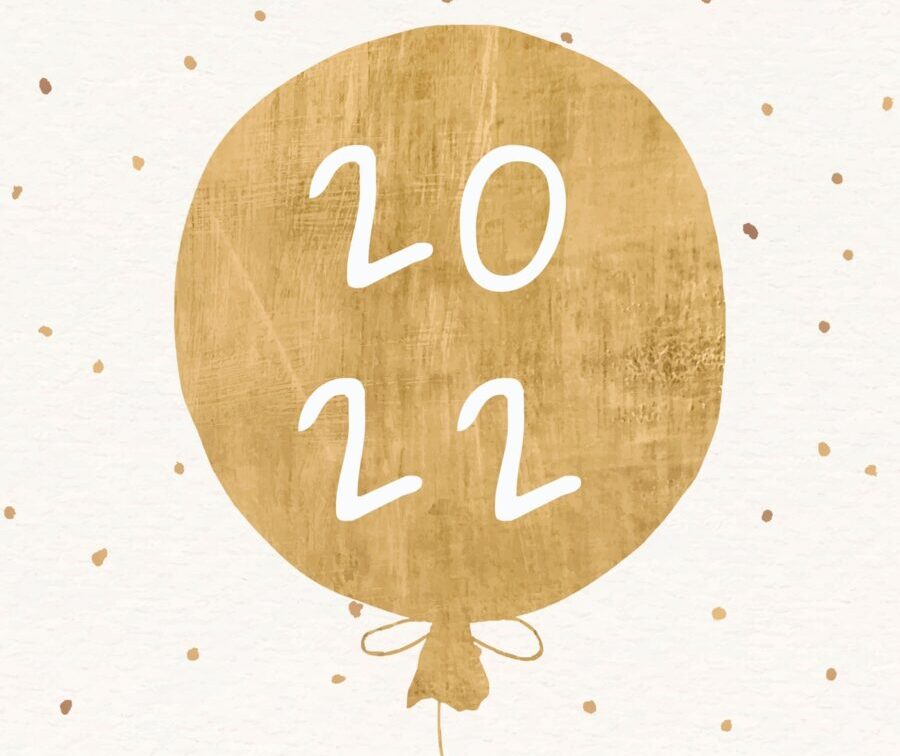 A gold balloon that says 2022 against a polka dot background to celebrate the New Year