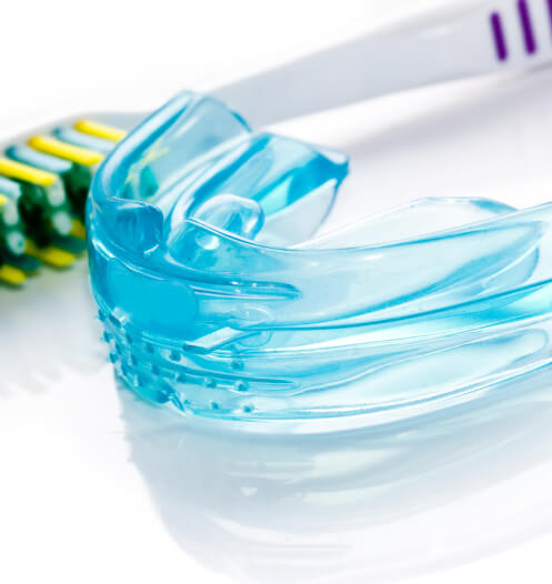 mouthguard next to a toothbrush